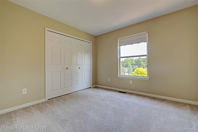 2338 Malena Ln, Oxford, MI 48371 - unfurnished bedroom featuring carpet floors, baseboards, and a closet