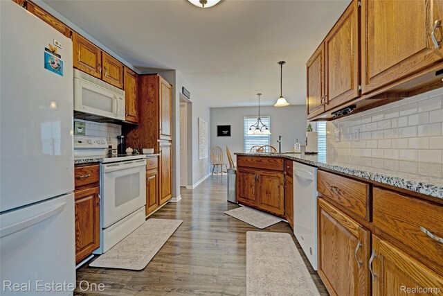 2338 Malena Ln, Oxford, MI 48371 - kitchen with white appliances, brown cabinets, decorative backsplash, and dark wood-style floors