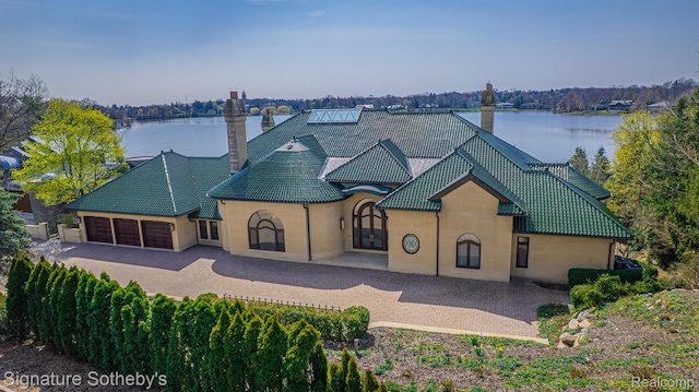 1567 Island Ln, Bloomfield Hills, MI 48302 - rear view of house with a chimney, a garage, a water view, and a tiled roof