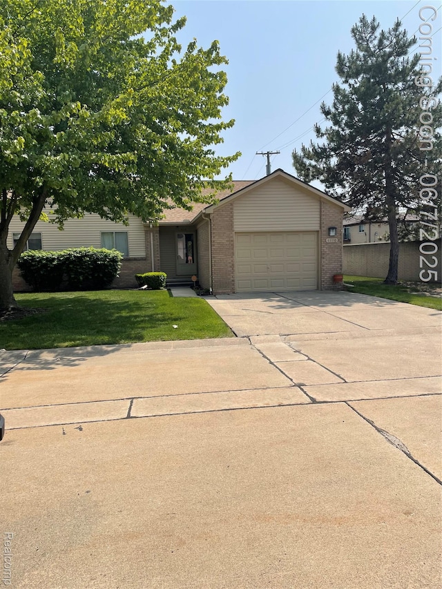 4110 W Cristina Ct S Unit 32, Warren, MI 48091 - view of front facade with brick siding, concrete driveway, a garage, and a front yard