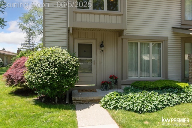 77 Willow Way Unit 13, Waterford, MI 48328 - doorway to property with board and batten siding and a yard