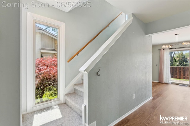 77 Willow Way Unit 13, Waterford, MI 48328 - stairway featuring a chandelier, wood finished floors, and baseboards
