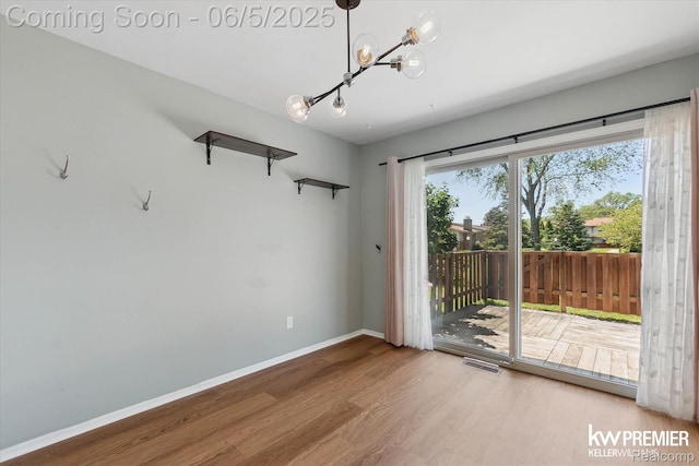 77 Willow Way Unit 13, Waterford, MI 48328 - spare room with wood finished floors, a chandelier, and baseboards