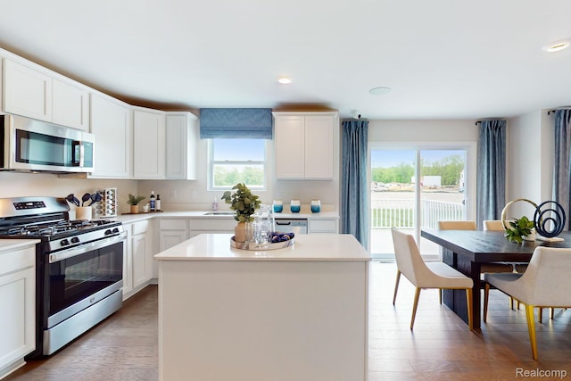378 Edge Brk, Holly, MI 48442 - kitchen featuring appliances with stainless steel finishes, a center island, light countertops, a sink, and light wood-type flooring