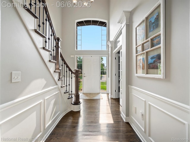 3924 High Grove Way, Lake Orion, MI 48360 - foyer entrance with stairs, a chandelier, dark wood-style floors, a towering ceiling, and a decorative wall