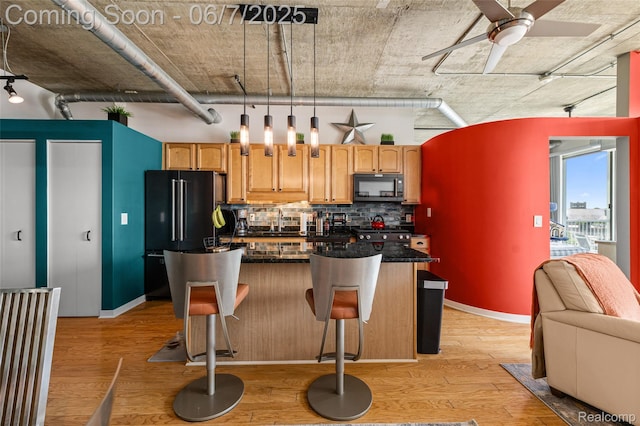 100 W 5th St Unit 504, Royal Oak, MI 48067 - kitchen featuring black microwave, freestanding refrigerator, backsplash, light wood-style flooring, and ceiling fan