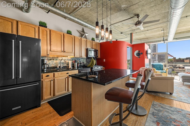 100 W 5th St Unit 504, Royal Oak, MI 48067 - kitchen featuring freestanding refrigerator, light wood-style flooring, a sink, backsplash, and stainless steel gas stove