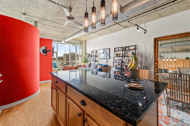 100 W 5th St Unit 504, Royal Oak, MI 48067 - kitchen featuring a ceiling fan, light wood-style floors, open floor plan, brown cabinetry, and baseboards
