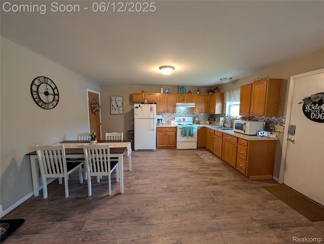 3070 Strong Hts, Grand Blanc, MI 48507 - kitchen featuring white appliances, dark wood finished floors, under cabinet range hood, backsplash, and light countertops