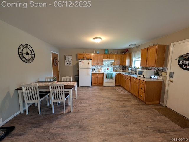 3070 Strong Hts, Grand Blanc, MI 48507 - kitchen featuring white appliances, under cabinet range hood, light countertops, and dark wood-style flooring