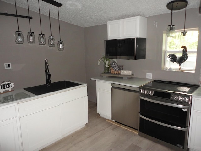 1920 S 15th St, Niles, MI 49120 - kitchen with double oven range, light wood-type flooring, white cabinets, a textured ceiling, and a sink