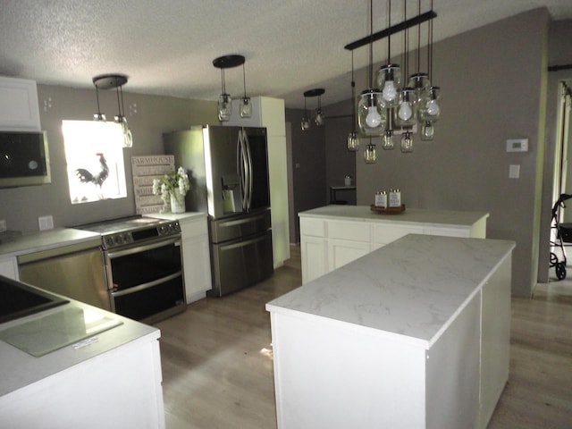 1920 S 15th St, Niles, MI 49120 - kitchen featuring stainless steel appliances, a center island, light wood-style floors, decorative light fixtures, and a textured ceiling