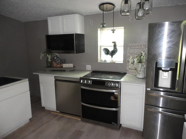 1920 S 15th St, Niles, MI 49120 - kitchen featuring stainless steel appliances, light wood-type flooring, white cabinetry, a textured ceiling, and light countertops