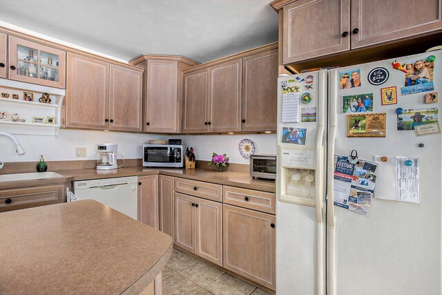 681 Gilead Shores Dr, Bronson, MI 49028 - kitchen featuring white appliances, a sink, light tile patterned flooring, and glass insert cabinets