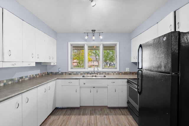 3030 Eastland Rd, Muskegon, MI 49441 - kitchen featuring freestanding refrigerator, a sink, electric stove, light wood-style floors, and white cabinets