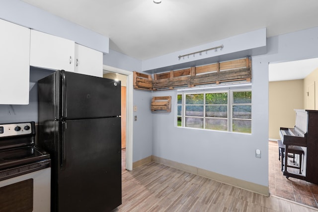 3030 Eastland Rd, Muskegon, MI 49441 - kitchen featuring stainless steel electric range oven, freestanding refrigerator, light wood-style flooring, white cabinets, and baseboards