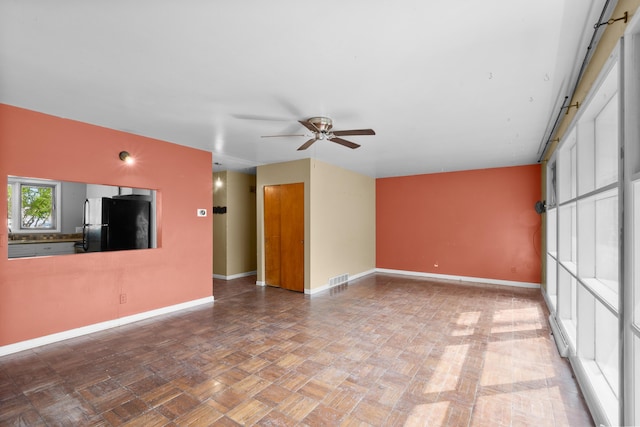 3030 Eastland Rd, Muskegon, MI 49441 - unfurnished living room featuring ceiling fan and baseboards