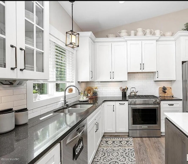 4087 Ronalds Rd, Dorr, MI 49323 - kitchen featuring stainless steel appliances, a sink, lofted ceiling, white cabinets, and hanging light fixtures