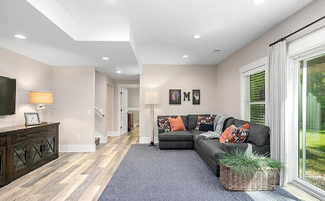 4087 Ronalds Rd, Dorr, MI 49323 - living room featuring light wood-style floors, healthy amount of natural light, recessed lighting, baseboards, and stairs