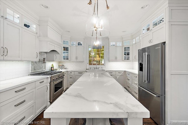 364 Chesterfield Ave, Birmingham, MI 48009 - kitchen featuring premium appliances, a center island, decorative backsplash, a chandelier, and a sink