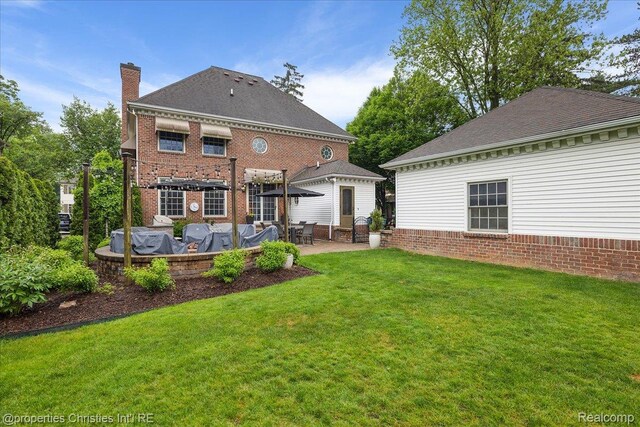 364 Chesterfield Ave, Birmingham, MI 48009 - rear view of property featuring a yard, a patio, a chimney, and a shingled roof