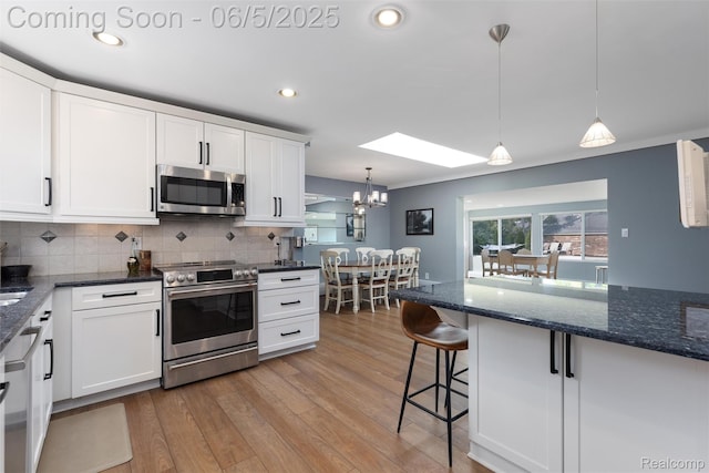 5908 Burnham Rd, Bloomfield Hills, MI 48302 - kitchen featuring appliances with stainless steel finishes, a skylight, white cabinets, tasteful backsplash, and recessed lighting
