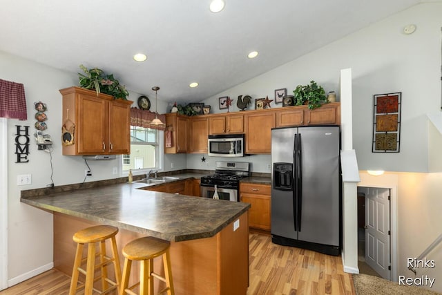 11185 Stanton St, West Olive, MI 49460 - kitchen with appliances with stainless steel finishes, brown cabinets, dark countertops, a sink, and recessed lighting