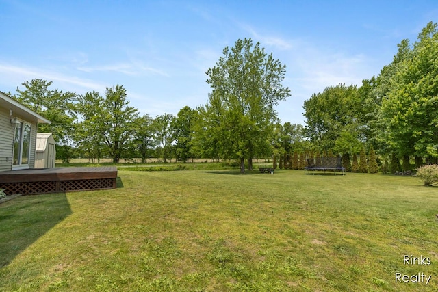 11185 Stanton St, West Olive, MI 49460 - view of green lawn with a trampoline and a deck