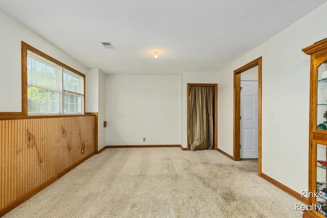 11185 Stanton St, West Olive, MI 49460 - carpeted empty room with a wainscoted wall and baseboards