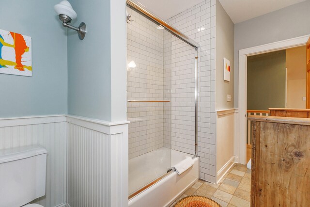 16434 S Basswood Rd, Three Oaks, MI 49128 - bathroom featuring toilet, wainscoting, combined bath / shower with glass door, vanity, and a decorative wall