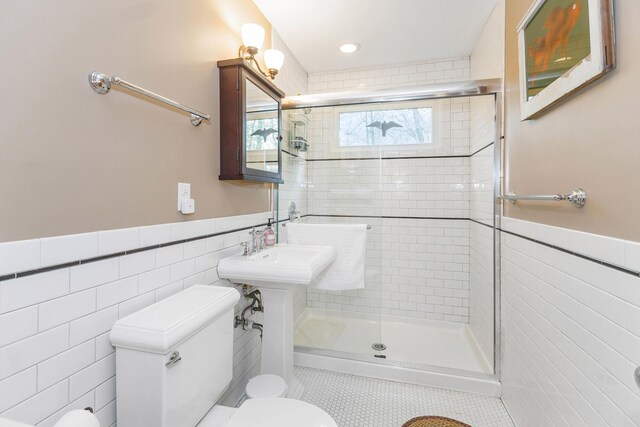 16434 S Basswood Rd, Three Oaks, MI 49128 - bathroom with tile walls, toilet, a shower stall, a wainscoted wall, and tile patterned flooring