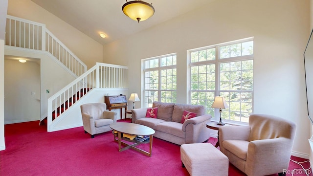 71 Grandview Cir, White Lake, MI 48386 - living room with healthy amount of natural light, stairway, a towering ceiling, carpet floors, and baseboards