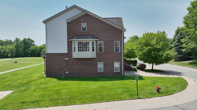 71 Grandview Cir, White Lake, MI 48386 - view of side of property with brick siding and a lawn