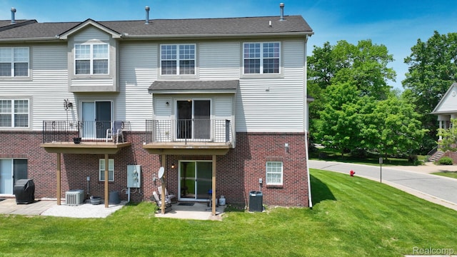 71 Grandview Cir, White Lake, MI 48386 - rear view of property featuring brick siding, a yard, a balcony, and a patio area