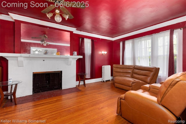 1475 Atkinson St, Detroit, MI 48206 - living area featuring radiator heating unit, a ceiling fan, wood finished floors, and plenty of natural light