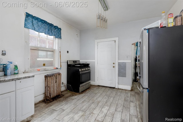 1475 Atkinson St, Detroit, MI 48206 - kitchen with appliances with stainless steel finishes, light wood-style floors, white cabinets, and light countertops