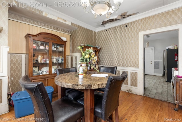 1475 Atkinson St, Detroit, MI 48206 - dining space featuring wallpapered walls, hardwood / wood-style flooring, ornamental molding, a wainscoted wall, and a chandelier