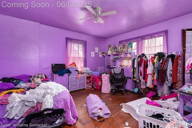 1475 Atkinson St, Detroit, MI 48206 - bedroom featuring radiator heating unit, multiple windows, wood finished floors, and a ceiling fan