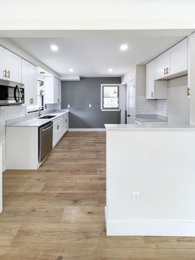 20215 Damman St, Harper Woods, MI 48225 - kitchen with stainless steel appliances, backsplash, a sink, white cabinets, and recessed lighting
