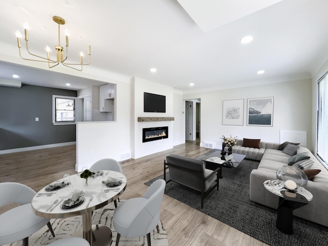 20215 Damman St, Harper Woods, MI 48225 - living room with a chandelier, light wood-style floors, recessed lighting, a glass covered fireplace, and baseboards