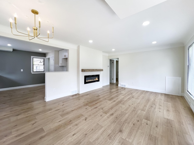 20215 Damman St, Harper Woods, MI 48225 - unfurnished living room featuring a chandelier, light wood-type flooring, recessed lighting, a glass covered fireplace, and baseboards