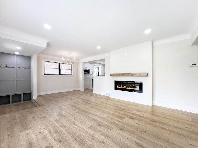20215 Damman St, Harper Woods, MI 48225 - unfurnished living room featuring light wood-type flooring, a chandelier, baseboards, recessed lighting, and a glass covered fireplace