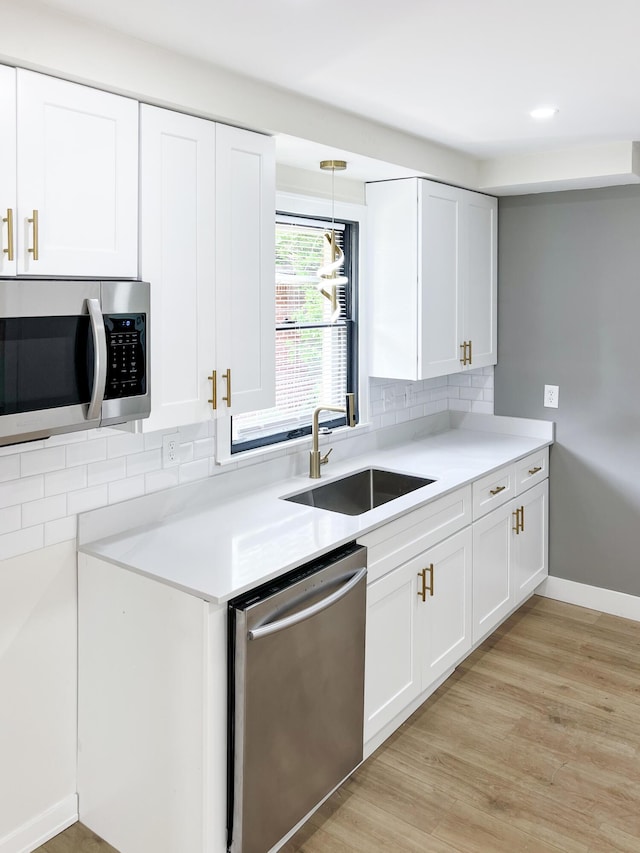 20215 Damman St, Harper Woods, MI 48225 - kitchen with appliances with stainless steel finishes, a sink, backsplash, and white cabinetry