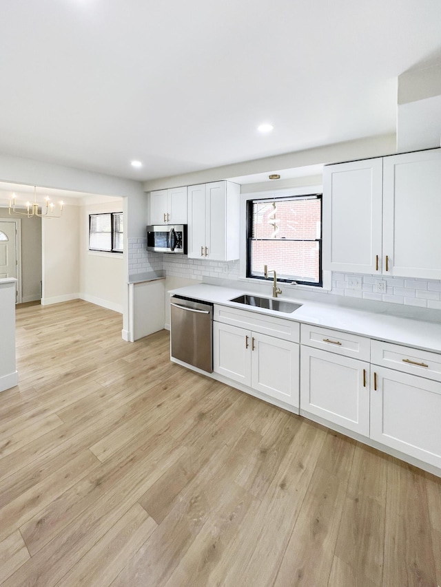 20215 Damman St, Harper Woods, MI 48225 - kitchen featuring stainless steel appliances, a sink, backsplash, white cabinets, and light countertops