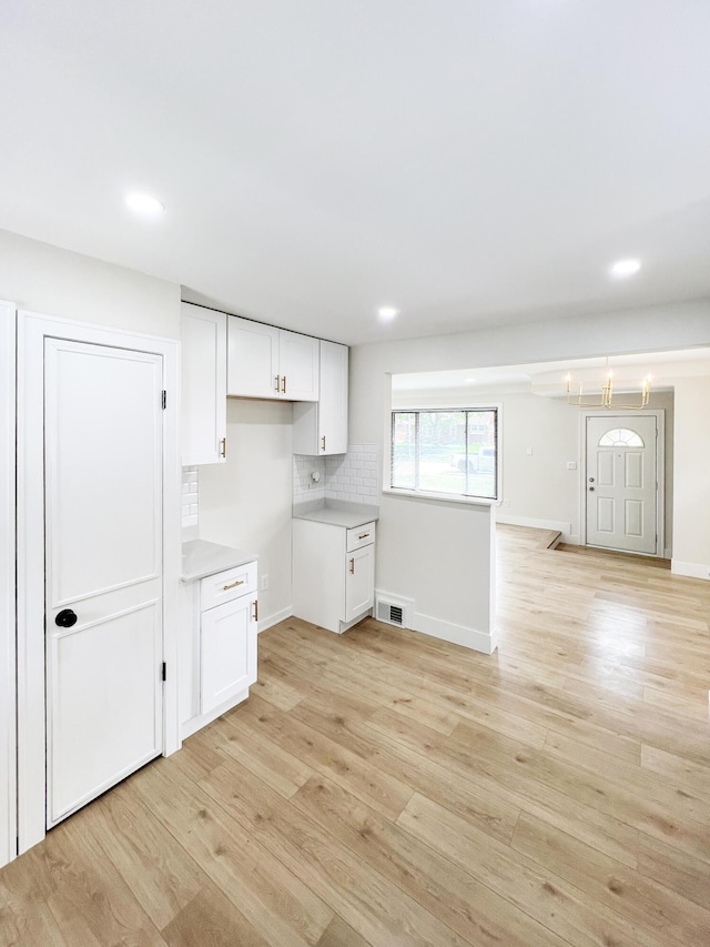 20215 Damman St, Harper Woods, MI 48225 - kitchen featuring light wood-type flooring, white cabinetry, backsplash, light countertops, and recessed lighting