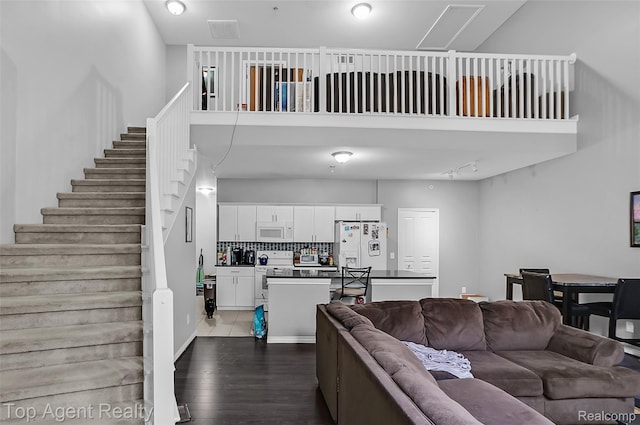 11685 Squiers Blvd, Utica, MI 48315 - living room featuring dark wood-style flooring, stairs, and a high ceiling