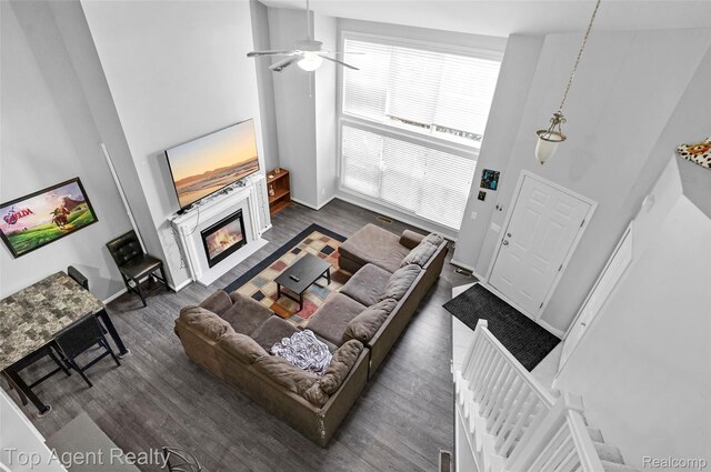 11685 Squiers Blvd, Utica, MI 48315 - living room with a glass covered fireplace, dark wood-style floors, ceiling fan, and a high ceiling