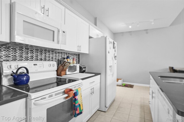 11685 Squiers Blvd, Utica, MI 48315 - kitchen with white appliances, dark countertops, white cabinets, and decorative backsplash