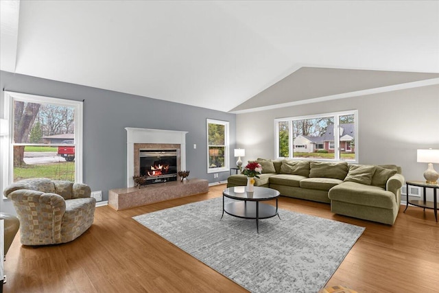2128 Somerset Rd, Bloomfield Hills, MI 48302 - living area with lofted ceiling, healthy amount of natural light, a premium fireplace, and wood finished floors