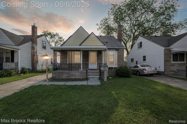 21426 Syracuse Ave, Warren, MI 48091 - bungalow-style home featuring covered porch, a yard, and stone siding